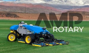 AMP Rotary AMP-X100 FireFly Autonomous Mowing Platform on green grass field with red rock and snowy mountains in background