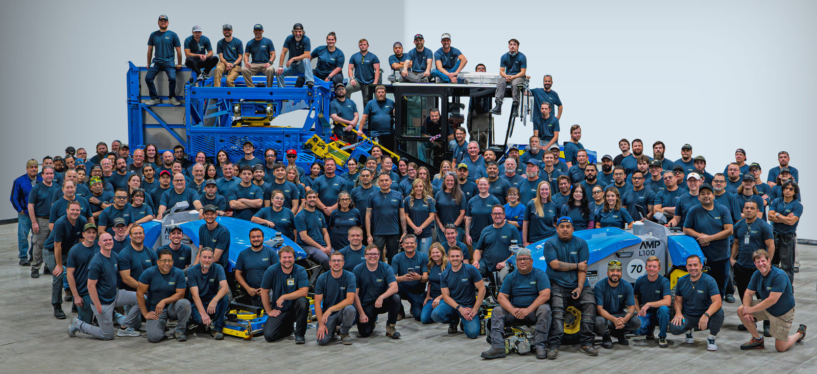 FireFly Robotics employees gathered around a sod harvester and two robotic lawn mowers